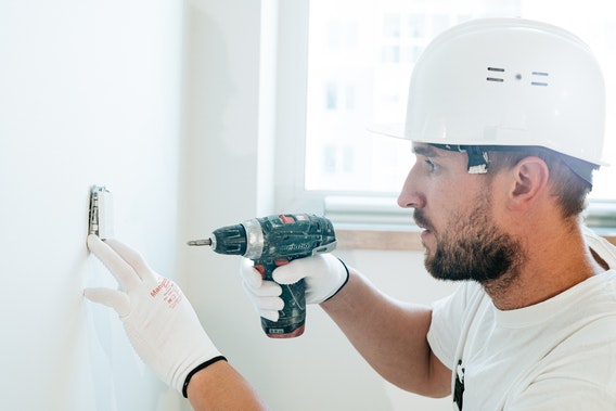 a contractor in a hard hat using a drill
